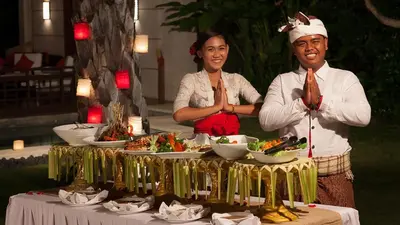 a man and woman standing next to a table with food at Villa The Beji in Canggu
