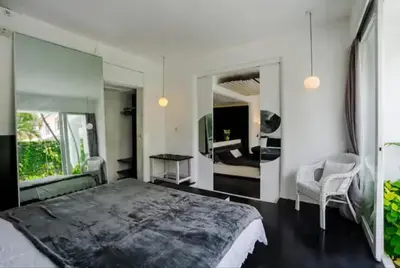 a bedroom with a large bed and a mirror at Villa with 2 Bedrooms & Private Bathrooms near to the beach Seminyak in Seminyak