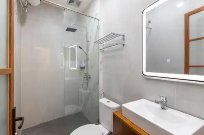 a bathroom with a toilet and a sink and a mirror at The Saren CoLiving by SooBali in Kerobokan