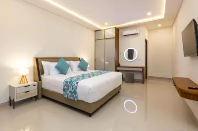 a bedroom with a bed and a tv in it at The Saren CoLiving by SooBali in Kerobokan