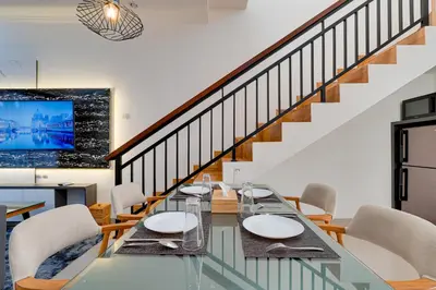 a dining room with a glass table and chairs at Stylish 3BR Villa Sandalwood near Beach in Seminyak