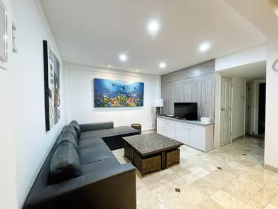 a living room with a couch and a television at Jayakarta 6508 Legian Beach Side 2 BR Apartment in Seminyak