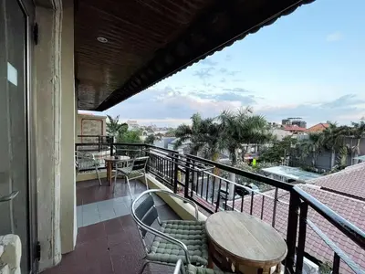 a balcony with a table and chairs and a view at Jayakarta 6508 Legian Beach Side 2 BR Apartment in Seminyak