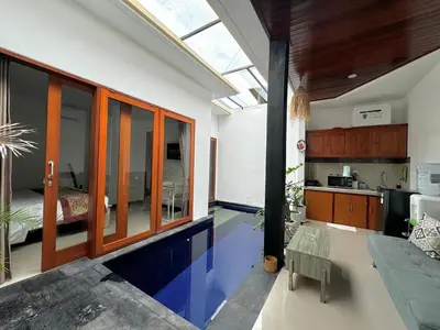 a house with a swimming pool in the middle of a room at CWB Villa in Kerobokan