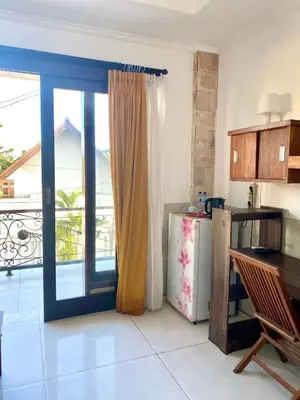a kitchen with a door open to a balcony at Karna Guest House in Seminyak