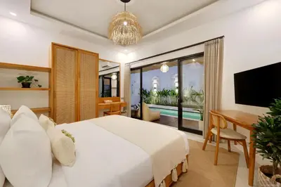 a bedroom with a bed and a desk and a television at Summer Cinta Seminyak in Seminyak