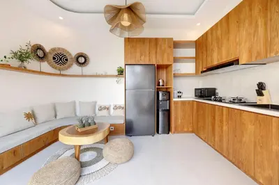 a kitchen with wooden cabinets and a stainless steel refrigerator at Summer Cinta Seminyak in Seminyak
