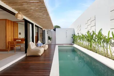 an infinity pool in the backyard of a house at Summer Cinta Seminyak in Seminyak
