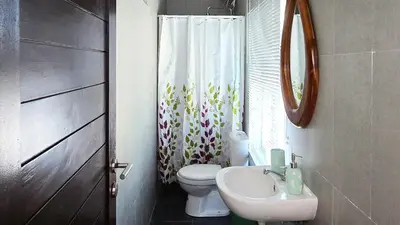 a bathroom with a toilet and a sink and a mirror at MauLagi Bali Getaway in Jimbaran