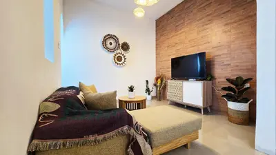 a living room with a couch and a flat screen tv at MauLagi Bali Getaway in Jimbaran