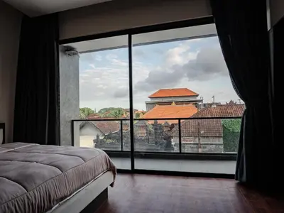 a bedroom with a large window with a view at Villa Maya in Kerobokan
