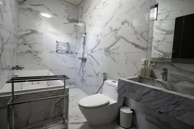 a white bathroom with a toilet and a sink at Villa Maya in Kerobokan