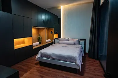 a bedroom with a large bed with black cabinets at Villa Maya in Kerobokan