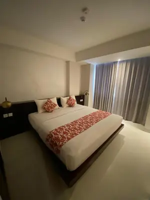a bedroom with a large bed and a window at Signature Seminyak in Seminyak
