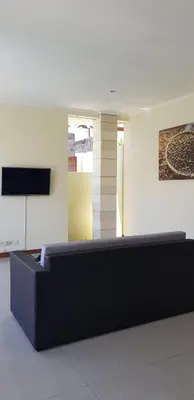a living room with a couch and a television at Privat Pool Villa with Kitchen at seminyak in Seminyak