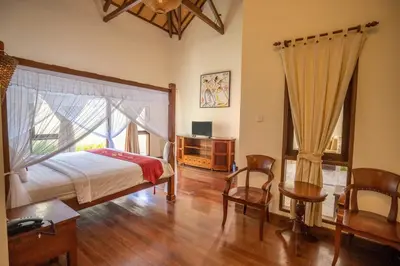 a bedroom with a bed and a table and chairs at Classic Pool villa with kitchen in Seminyak