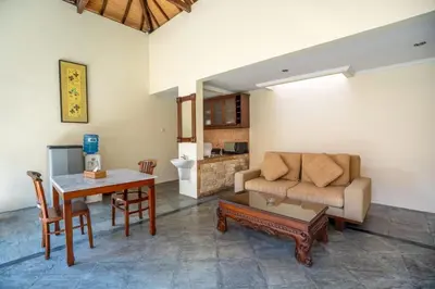 a living room with a couch and a table at Classic Pool villa with kitchen in Seminyak