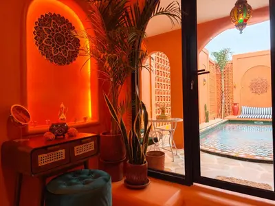 an orange room with a swimming pool and a window at Güzel Villa Bali in Badung