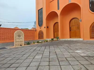 an orange building with a gate and a stone grave at Güzel Villa Bali in Badung