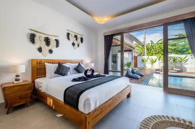 a bedroom with a large bed and a pool at Harmony Villa Two Bedroom in Canggu