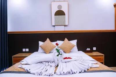 a bed with white sheets and flowers on it at D'House Seminyak in Seminyak