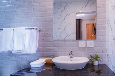 a bathroom with a sink and a mirror and towels at D'House Seminyak in Seminyak
