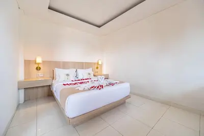 a bedroom with a large white bed in a room at Srikrisna in Seminyak