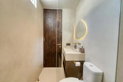 a bathroom with a toilet and a sink and a mirror at Villa Madame 3BR Villa Private Pool in Berawa in Canggu