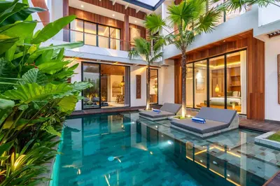 an infinity pool in a villa with palm trees at Gelareh Villa Berawa in Canggu