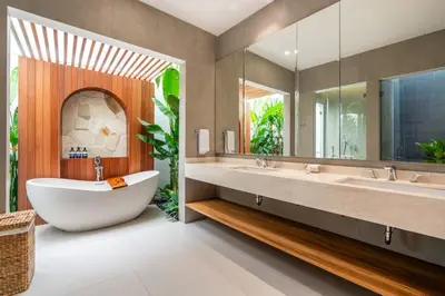 a bathroom with a large tub and a large mirror at Gelareh Villa Berawa in Canggu