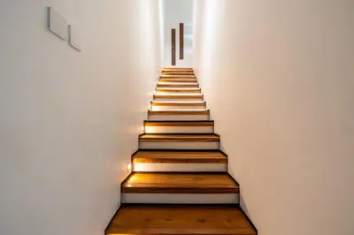 a staircase with wooden steps in a room with lights at Gelareh Villa Berawa in Canggu