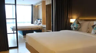 a hotel room with a bed and a balcony at Esco Luxe Benoa in Nusa Dua