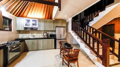 a kitchen with a staircase and a table and chairs at Sandy Shores Bali in Seminyak