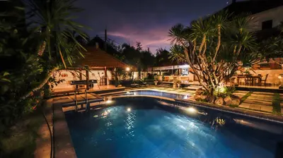 a swimming pool in a resort at night at Sandy Shores Bali in Seminyak