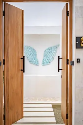 a door into a hallway with a wings wreath at Soft Opening! Villa Lumière 1 Seminyak in Seminyak