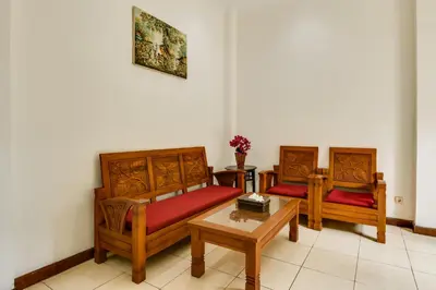 two beds and a table in a room at Gracia Apartment Seminyak Managed by Manara in Seminyak