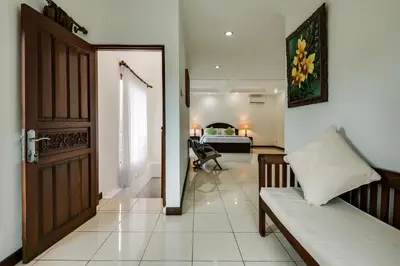 a room with a door and a couch and a bedroom at Gracia Apartment Seminyak Managed by Manara in Seminyak