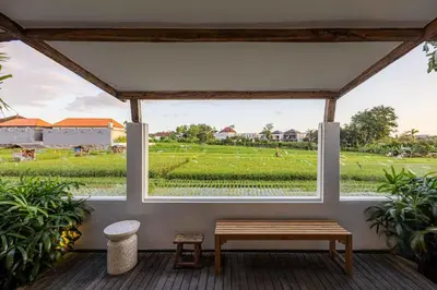 a porch with a bench and a view of a field at Villa Rice - Amazing Rice-Field VIEW 3BR Villa 9px Next To Canggu in Kerobokan