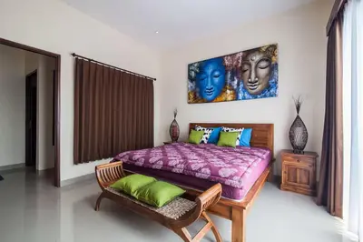 a bedroom with a large bed with a purple blanket at The Lavana Villa De Kerobokan in Seminyak