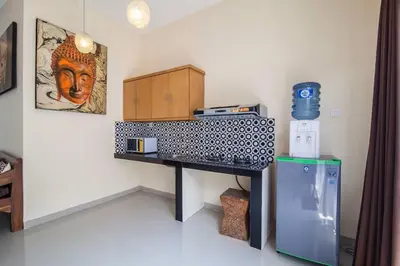 a room with a desk and a refrigerator at The Lavana Villa De Kerobokan in Seminyak
