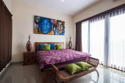 a bedroom with a purple bed with a painting on the wall at The Lavana Villa De Kerobokan in Seminyak