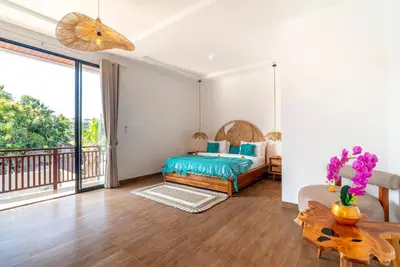 a bedroom with a bed and a balcony at Villa Bella Wilson 4 in Seminyak