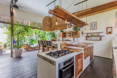 a kitchen with an island with a stove top oven at Villa Ubuntu 3BR Pool Ricefield Family&Friends group near Canggu in Kerobokan