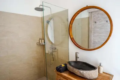 a bathroom with a sink and a mirror at Villa Vaimala 4BR Pool Tropical Home Seminyak in Seminyak