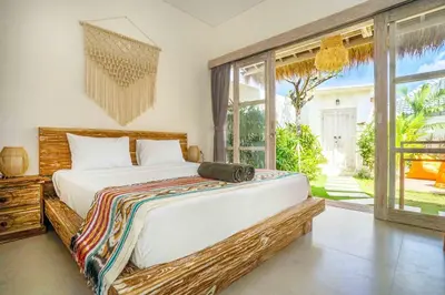 a bedroom with a large bed and a large window at Villa Vaimala 4BR Pool Tropical Home Seminyak in Seminyak