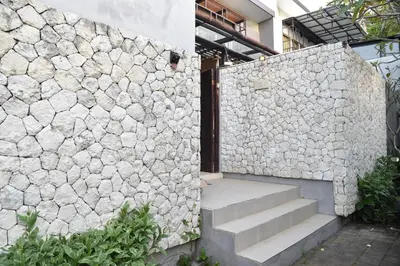 a stone wall with a staircase next to a building at Casa Nakoa 2BR With Private Pool in Nusa Dua