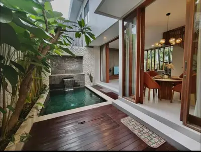 a swimming pool in the middle of a house with a fireplace at Villa Mirana in Seminyak