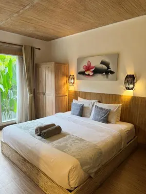 a bedroom with a large bed in a room at Kubu Betel Home Stay in Canggu