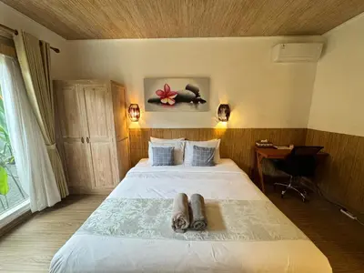a bedroom with a bed with two animals laying on it at Kubu Betel Home Stay in Canggu