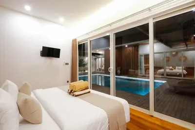 a hotel room with a bed and a swimming pool at Anama Villa Kerobokan in Seminyak